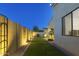 Backyard featuring artificial grass, decorative privacy wall and lighting on a clear evening at 948 E La Mirada Dr, Phoenix, AZ 85042