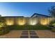 Backyard with privacy wall, artificial grass, uplighting, and a stone path at 948 E La Mirada Dr, Phoenix, AZ 85042