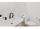 Clean bathroom features a sleek sink, modern black faucet, and a toilet with white walls at 948 E La Mirada Dr, Phoenix, AZ 85042
