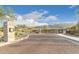 Community entrance gate with paved road, landscaping, and desert mountain views under a bright blue sky at 948 E La Mirada Dr, Phoenix, AZ 85042