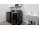 Convenient laundry room with modern washer and dryer units, sink, and storage shelf at 948 E La Mirada Dr, Phoenix, AZ 85042