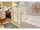 Luxurious bathroom featuring a walk-in shower, soaking tub, and seamless connection to a walk-in closet at 10005 N 1St Dr, Phoenix, AZ 85021