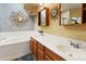 Elegant bathroom featuring double sinks, a tub, and decorative mirrors, blending style and functionality at 10005 N 1St Dr, Phoenix, AZ 85021