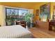 Serene bedroom with hardwood floors, mountain views, plants, and desk area bathed in natural light from large windows at 10005 N 1St Dr, Phoenix, AZ 85021