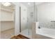 Modern bathroom featuring walk in shower and a soaking tub with white subway tile at 10417 W Alyssa Ln, Peoria, AZ 85383