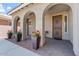Inviting covered front porch with arched entryways, potted plants, and stylish tile flooring at 10417 W Alyssa Ln, Peoria, AZ 85383