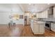 Open-concept kitchen with granite counters, island, stainless appliances, and wood-look floors at 10417 W Alyssa Ln, Peoria, AZ 85383
