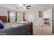 This cozy bedroom features an elegant wooden bed frame, soft carpet, and a ceiling fan at 10561 E Plata Ave, Mesa, AZ 85212