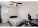 Cozy bedroom featuring a ceiling fan, window with blinds, and desk with gaming chair setup at 10561 E Plata Ave, Mesa, AZ 85212