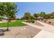 Landscaped community area with walking paths, green grass and desert landscaping at 10561 E Plata Ave, Mesa, AZ 85212