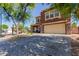 Inviting two-story home with desert landscaping, front porch seating, and a spacious driveway leading to a two-car garage at 10561 E Plata Ave, Mesa, AZ 85212