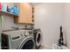 Well-equipped laundry room with modern washer and dryer, upper cabinets, and storage space at 10561 E Plata Ave, Mesa, AZ 85212