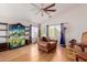 Spacious living room featuring hardwood flooring, a ceiling fan, and a comfortable leather armchair at 10561 E Plata Ave, Mesa, AZ 85212