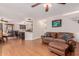 Spacious living room featuring hardwood floors, a ceiling fan, a plush leather sofa and view of the kitchen at 10561 E Plata Ave, Mesa, AZ 85212