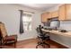 Functional home office space with built-in desk, cabinets, a large window, and wood floors at 10561 E Plata Ave, Mesa, AZ 85212