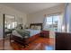 Bedroom with mirrored closet doors, wood floors, and a sunlit window at 11333 N 92Nd St # 1085, Scottsdale, AZ 85260