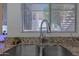A close-up of kitchen sink with granite countertop, stainless steel faucet and view of outdoors at 11333 N 92Nd St # 1085, Scottsdale, AZ 85260