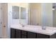 Bathroom double vanity featuring dark wood cabinets, framed mirrors and tile floor at 13549 W Paso Trl, Peoria, AZ 85383