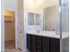 Double vanity bathroom with tile floor, dark cabinets and framed mirrors at 13549 W Paso Trl, Peoria, AZ 85383