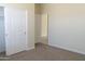 Bedroom with neutral carpet and three doors to closet, hallway and another room at 13549 W Paso Trl, Peoria, AZ 85383