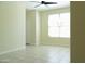 Bright bedroom with ceiling fan and window providing natural light and neutral toned walls and tiled flooring at 13549 W Paso Trl, Peoria, AZ 85383