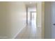 View of a long hallway with tan walls and tile floors that leads to the sliding glass doors at 13549 W Paso Trl, Peoria, AZ 85383