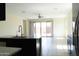 Open-concept kitchen with modern faucet, dark cabinets, and glass sliding doors at 13549 W Paso Trl, Peoria, AZ 85383