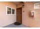 Exterior front door of unit 135 featuring a decorative mat, window, and stucco siding at 13700 N Fountain Hills Blvd # 135, Fountain Hills, AZ 85268