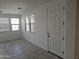 Well-lit living room with tile flooring, windows, and a white front door at 14224 W Hackamore Dr, Surprise, AZ 85387