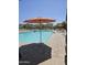 A refreshing swimming pool under the summer sky with lounge chairs and umbrellas for relaxation and enjoyment at 14224 W Hackamore Dr, Surprise, AZ 85387