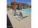 Relaxing poolside view with lounge chairs, tables, and shaded seating areas, perfect for summer gatherings at 14224 W Hackamore Dr, Surprise, AZ 85387