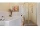 Elegant bathroom featuring a soaking tub, a glass enclosed shower, and tiled walls at 14250 W Wigwam Blvd # 2126, Litchfield Park, AZ 85340