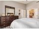 Inviting bedroom featuring a large bed, dark wood dresser, and ensuite bathroom access at 14250 W Wigwam Blvd # 2126, Litchfield Park, AZ 85340