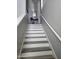 Bright stairway featuring gray wood treads, white risers, and a decorative wrought iron console table at 14250 W Wigwam Blvd # 2126, Litchfield Park, AZ 85340
