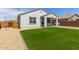 Backyard featuring a well-manicured artificial lawn that meets the white stucco exterior at 14269 W El Cortez Pl, Surprise, AZ 85387