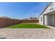 Expansive backyard featuring lush artificial grass, a paver patio, and a block fence for added privacy at 14269 W El Cortez Pl, Surprise, AZ 85387