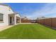 A well-manicured backyard featuring artificial turf, patio, and gravel landscaping at 14269 W El Cortez Pl, Surprise, AZ 85387