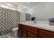 Cozy bathroom with a vanity with drawers, framed mirror, and a shower with patterned curtain at 14269 W El Cortez Pl, Surprise, AZ 85387
