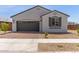 Charming single-story home with a brick driveway, gray stucco, and neat landscaping at 14269 W El Cortez Pl, Surprise, AZ 85387
