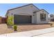 Exterior view of home with a brick driveway, neutral paint, and rock landscaping at 14269 W El Cortez Pl, Surprise, AZ 85387