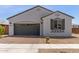 Well-maintained single-story home with a brick driveway, gray stucco exterior, and neat landscaping at 14269 W El Cortez Pl, Surprise, AZ 85387
