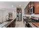 Modern kitchen featuring granite countertops, stainless steel appliances, and dark wood cabinets at 14269 W El Cortez Pl, Surprise, AZ 85387