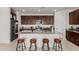Open kitchen featuring a large island, granite countertops, stainless steel appliances, and dark wood cabinets at 14269 W El Cortez Pl, Surprise, AZ 85387