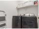 Functional laundry room equipped with modern washer and dryer units, and shelf space at 14269 W El Cortez Pl, Surprise, AZ 85387