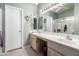 Bathroom with double sinks, mirrors, tiled floors and shower, and white cabinets at 15395 W Pinchot Ct, Goodyear, AZ 85395