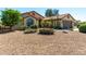 Landscaped front yard with desert plants, rocks, a lush green tree, and a tile roof home at 15395 W Pinchot Ct, Goodyear, AZ 85395
