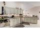 Well-lit kitchen with white cabinets, granite countertops, and an open layout to the living area at 15395 W Pinchot Ct, Goodyear, AZ 85395
