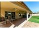 Covered patio featuring brick flooring, ceiling fans, and views of the lush backyard at 15395 W Pinchot Ct, Goodyear, AZ 85395