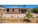 Backyard featuring a covered patio and desert landscape with trees and plants at 15471 W Post Cir, Surprise, AZ 85374