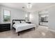 Light-filled bedroom boasts a modern chandelier, beautiful wainscoting and ensuite bathroom at 15471 W Post Cir, Surprise, AZ 85374